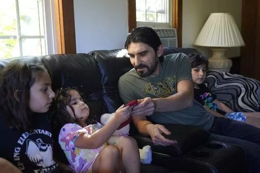Mohammad Walizada, center right, who fled Afghanistan with his family, sits with three of his children, from the left, Zahra, 10, Hasnat, 3, and Mohammad Ibrahim, 7, Thursday, Sept. 15, 2022, at their home, in Epping, N.H. Since the U.S. military's withdrawal from Kabul last year, the Sponsor Circle Program for Afghans has helped over 600 Afghans restart their lives in their communities. Now the Biden administration is preparing to turn the experiment into a private-sponsorship program for refug