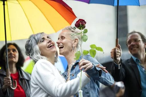 Annett Babinsky, right, and Laura Suarez celebrate their marriage at the registry office 'Amtshaus' in Zurich, Switzerland, Friday, July 1, 2022.  After a yes vote in the "Marriage for All" vote last fall, from July 1, same-sex couples marriage for the first time in Switzerland. (Ennio Leanza/Keystone via AP)