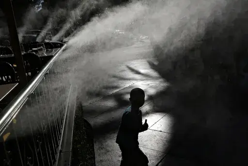 A child keeps cool beneath misters along the Las Vegas Strip, Friday, June 16, 2017, in Las Vegas. Pediatricians suggest keeping your child hydrated and avoiding prolonged sun exposure to keep heat illness at bay. (AP Photo/John Locher, File)