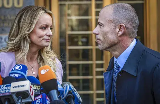 Adult film actress Stormy Daniels, left, stands with her lawyer Michael Avenatti during a news conference outside federal court in New York, April 16, 2018. Avenatti was convicted Friday, Feb. 4, 2022, by a jury on charges that he cheated porn actor Stormy Daniels out of nearly $300,000 she was supposed to get for writing a book about an alleged tryst with former president Donald Trump. (AP Photo/Mary Altaffer, File)