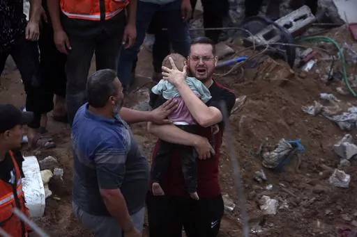 A Palestinian man cries while holding a dead child who was found under the rubble of a destroyed building following Israeli airstrikes in Nusseirat refugee camp, central Gaza Strip on Oct. 31, 2023. In just 25 days of war, more than 3,600 Palestinian children have been killed in Gaza, according to Gaza's Hamas-run Health Ministry. The advocacy group Save The Children says more children were killed in Gaza in October 2023 than in all conflict zones around the world combined in 2022. (AP Photo/Moh