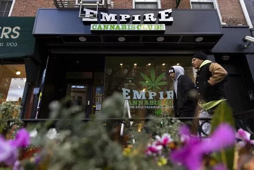 People walk past the Empire Cannabis Club, Wednesday, Nov. 16, 2022, in New York. Under pressure to launch one of the nation’s most hotly anticipated legal marijuana markets, the state Cannabis Control Board is set Monday to consider awarding some dispensary licenses to entrepreneurs and nonprofit groups — a major step that comes as cannabis regulators stress that they're trying to stop unlicensed sellers. (AP Photo/Julia Nikhinson)