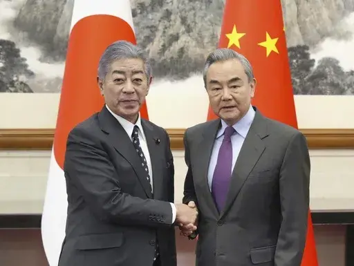 Japan's Foreign Minister Takeshi Iwaya, left, and Chinese Foreign Minister Wang Yi, right, shake hands in Beijing's Diaoyutai State Guesthouse Wednesday, Dec. 25, 2024. (Kyodo News via AP)