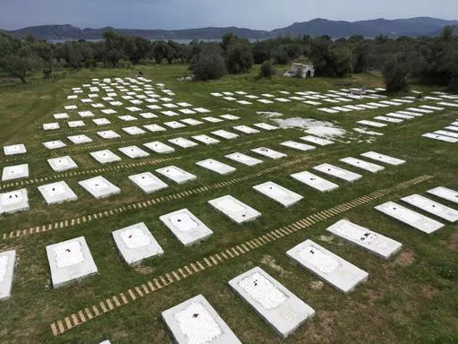 A cemetery is seen from above at Kato Tritos village on the northeastern Aegean Sea island of Lesbos, Greece, on Wednesday, April 17, 2024. After years of neglect, a primitive burial ground for refugees who died trying to reach Greece's island of Lesbos has been cleaned up and redesigned to provide a dignified resting place for the dead. (AP Photo/Panagiotis Balaskas)