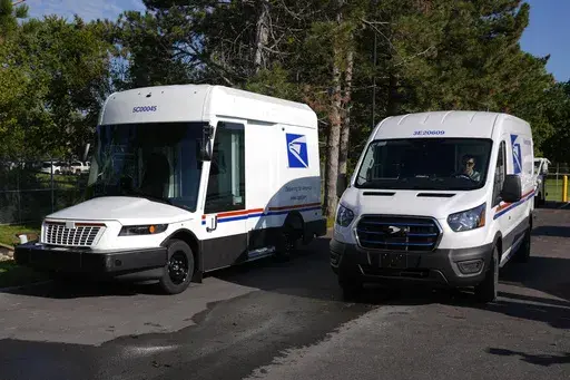The U.S. Postal Service's next-generation delivery vehicle, left, is displayed as one new battery electric delivery trucks leaves the Kokomo Sorting and Delivery Center in Kokomo, Ind., Thursday, Aug. 29, 2024. (AP Photo/Michael Conroy, File)