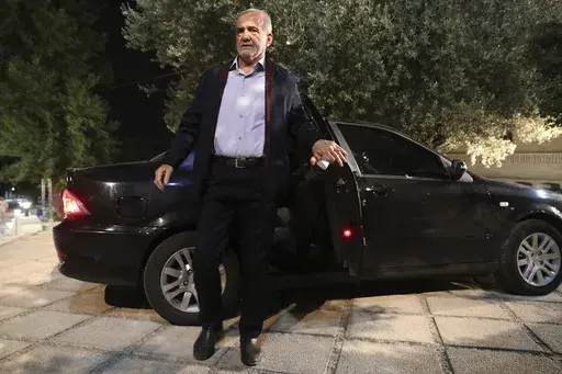 In this picture made available by Iranian state-run TV, IRIB, reformist candidate for the presidential election Masoud Pezeshkian arrives for his debate with the hard-line candidate Saeed Jalili at the TV studio in Tehran, Iran, Monday, July 1, 2024. (Morteza Fakhri Nezhad/IRIB via AP)