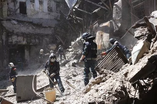 Donetsk People Republic Emergency Situations Ministry employees clear rubble at the side of the damaged Mariupol theater building during heavy fighting in Mariupol, in territory under the government of the Donetsk People's Republic, eastern Ukraine, Thursday, May 12, 2022. (AP Photo)