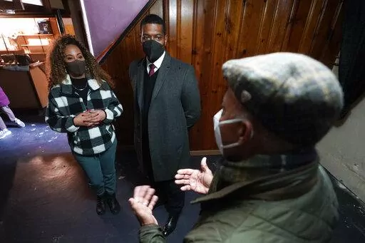 Tilicia Owens and Environmental Protection Agency Administrator Michael Regan, center, listen to Detroit Water and Sewerage Department director Gary Brown in her basement Friday, Feb. 18, 2022, in Detroit. They discussed the city’s $15 million effort to provide flood prevention pumps and other equipment in 11 neighborhoods. Part of the money will come from the $350 billion Coronavirus State and Local Fiscal Recovery Funds which can be used by states, counties and cities to recover from the pan