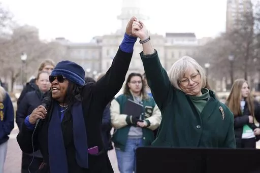 Michigan state Rep. Brenda Carter, D-Pontiac, left, and state Sen. Rosemary Bayer, D-Keego Harbor, join hands during a news conference to call for gun reform, Feb. 20, 2023, in Lansing, Mich. Michigan Democrats are poised to bring an 11-bill package to the Legislature next week that would implement safe storage laws, universal background checks and extreme risk protection orders, also known as red flag laws. A February mass shooting at MSU pushed Democrats to act fast on legislation they had alr