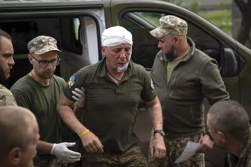 Ukrainian soldiers help their wounded fellow at a medical stabilisation point near Bakhmut, Donetsk region, Ukraine, Wednesday, May 24, 2023. (AP Photo/Efrem Lukatsky)