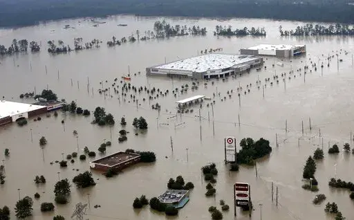 FILE-In this Tuesday, Aug. 29, 2017 file photo, Businesses are surrounded by floodwaters from Tropical Storm Harvey, in Humble, Texas. Extreme weather is becoming more common, and that's just one of the warnings for the Gulf of Mexico region in a United Nations report released this week. (AP Photo/David J. Phillip, File)