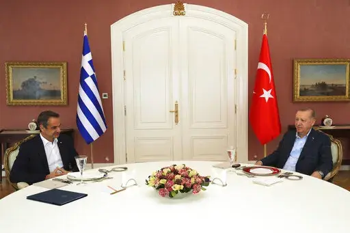 In this photo provided by Turkish Presidency, Greek Prime Minister Kyriakos Mitsotakis, left, talks to Turkish President Recep Tayyip Erdogan during their meeting in Istanbul, Turkey, Sunday, March 13, 2022. Mitsotakis is in Istanbul to talk with Turkish President Recep Tayyip Erdogan in a rare meeting between the neighbors who have been at odds over maritime and energy issues, the status of Aegean islands and migration. (Turkish Presidency via AP)