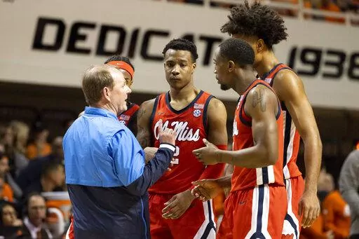 Mississippi head coach Kermit Davis, left, talks with players, from left to right, Amaree Abram, TJ Caldwell, Jaemyn Brakefield and Tye Fagan in the second half of an NCAA college basketball game against Oklahoma State in Stillwater, Okla., Saturday, Jan. 28, 2023. (AP Photo/Mitch Alcala)