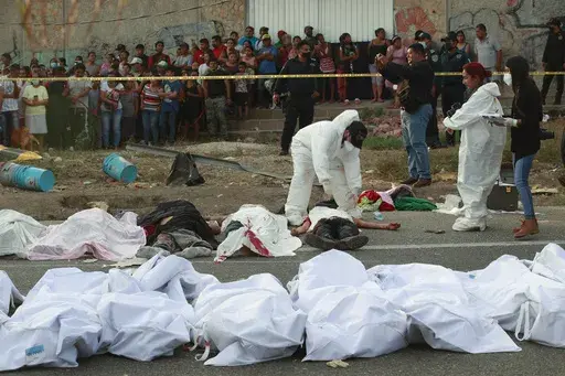 Bodies in bodybags are placed on the side of the road after a deadly semi-trailer truck crash in Tuxtla Gutierrez, Chiapas state, Mexico, Dec. 9, 2021. (AP Photo, File)