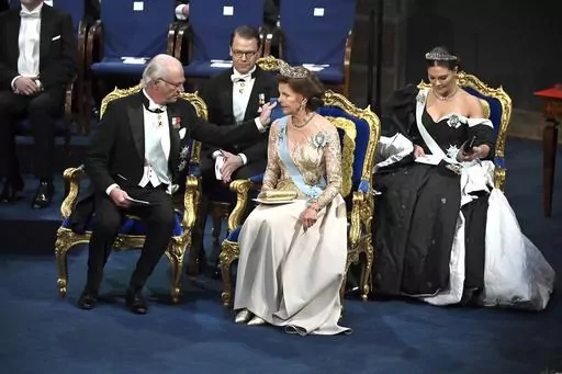 Sweden's King Carl Gustaf adjusts a pillow for Queen Silvia at the Nobel award ceremony at Stockholm Concert Hall, in Stockholm, on Tuesday Dec. 10, 2019. (Claudio Bresciani / TT Pool via AP, File)