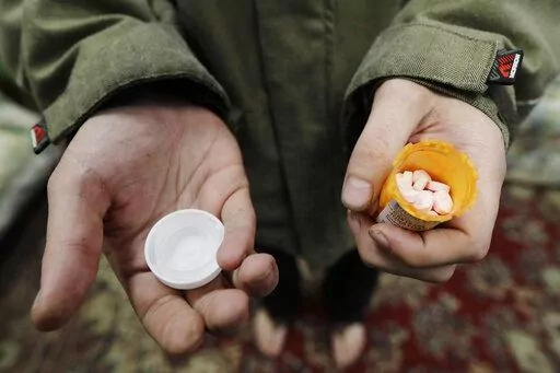 In this Nov. 14, 2019, photo, Jon Combes holds his bottle of buprenorphine, a medicine that prevents withdrawal sickness in people trying to stop using opiates, as he prepares to take a dose in a clinic in Olympia, Wash. The U.S. Department of Justice made clear, Tuesday, April 2, 2022, that barring the use of medication treatment for opioid abuse is a violation of federal law. (AP Photo/Ted S. Warren, File)