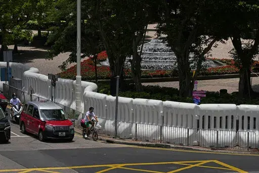 Water-filled barriers have been installed by police outside the Hong Kong Convention and Exhibition Centre where the inauguration ceremony of the newly-appointed Chief Executive John Lee will take place in Hong Kong, Monday, June 27, 2022. Questions continue to circle over whether Chinese leader Xi Jinping will attend the 25th year anniversary of Hong Kong's handover from British to Chinese rule and the inauguration of of the territory's new leader. (AP Photo/Kin Cheung)