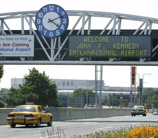 A clock at the entrance to JFK Airport in New York is pictured on Aug. 15, 2003. Officials are investigating a close call at the New York airport that happened Friday, Jan. 13, 2023, between a plane that was crossing a runway and another that was preparing for takeoff. (AP Photo/Stuart Ramson, File)