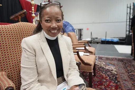 Rev. Dorothy Sanders Wells, a native of Mobile, Ala., sits on a stage at St. Andrew's Episcopal School campus in Ridgeland, Miss., Friday, July 19, 2024, before being formally installed Saturday as the first woman and first Black person to hold the post of bishop of the Episcopal Diocese of Mississippi. (AP Photo/Rogelio V. Solis)