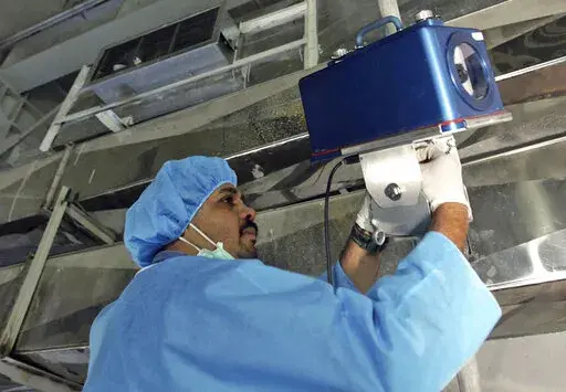 An inspector of the International Atomic Energy Agency sets up surveillance equipment, at the Uranium Conversion Facility of Iran, just outside the city of Isfahan, Iran, Aug. 8, 2005. Iran turned off two surveillance cameras of the United Nations' nuclear watchdog that monitored one of its atomic sites, state television reported Wednesday, June 8, 2022. The report did not identify the site. (AP Photo/Mehdi Ghasemi, ISNA, File )