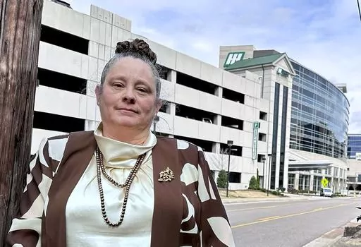 Dana Holladay-Hollifield poses for a photo in front of Hunstville Hospital, in Huntsville, Ala., Feb. 27, 2024. Holladay-Hollifield has worked as a nurse in Alabama for years, but never was her pay as low as it was at Huntsville Hospital. (Amanda Shavers/The Cullman Times via AP)