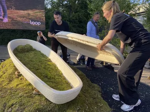 Director Lonneke Westhoff, right, and founder Bob Hendrikx, left, of Dutch startup Loop Biotech display one of the cocoon-like coffins, grown from local mushrooms and up-cycled hemp fibres, designed to dissolve into the environment amid growing demand for more sustainable burial practices, in Delft, Netherlands, Monday, May 22, 2023. A Dutch intrepid inventor is now “growing” coffins by putting mycelium, the root structure of mushrooms, together with hemp fiber in a special mold that, in a w