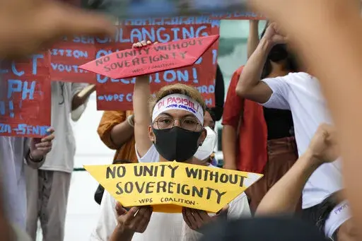 Protesters hold slogans to mark the 6th anniversary of the issuance of the 2016 decision by an arbitration tribunal set up under the U.N. Convention of the Law of the Sea after the Philippines complained against China's increasingly aggressive actions in the disputed sea during a rally outside the Chinese consulate in Makati, Philippines, Tuesday, July 12, 2022. U.S. Secretary of State Antony Blinken renewed a call to China to comply with a 2016 arbitration ruling that invalidated Beijing's vast