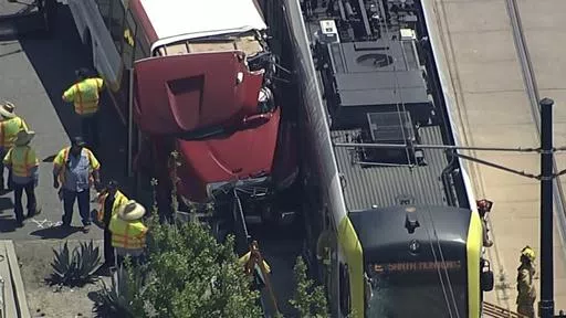 In this aerial still image provided by KABC-TV, firefighters respond to the scene of an accident where a shuttle bus collided with a Metro light rail train on Tuesday, April 30, 2024, in Los Angeles. (KABC via AP)