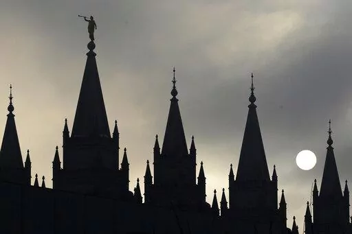 The angel Moroni statue atop the Salt Lake Temple is silhouetted against a cloud-covered sky, at Temple Square in Salt Lake City on Feb. 6, 2013. (AP Photo/Rick Bowmer, File)