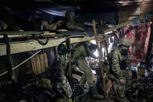 Ukrainian paratroopers of 80 Air Assault brigade rest inside a dugout at the frontline near Bakhmut, Ukraine, Friday, March 10, 2023. (AP Photo/Evgeniy Maloletka)