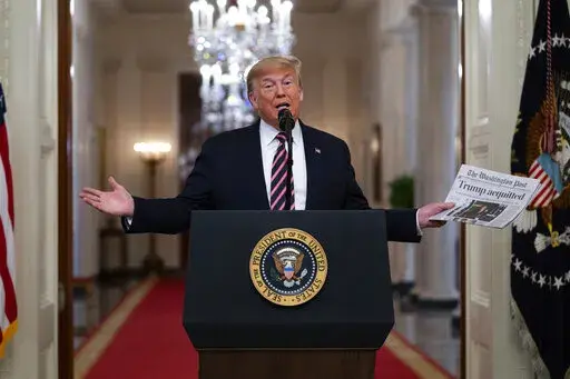 President Donald Trump holds up a newspaper with a headline that reads "Trump acquitted" during an event celebrating his impeachment acquittal, in the East Room of the White House, Feb. 6, 2020, in Washington. The impeachment investigation, sparked by a government whistleblower's complaint over Trump's call, swiftly became a milestone, the first in a generation since Democrat Bill Clinton faced charges over an affair with a White House intern. (AP Photo/Evan Vucci, File)