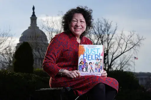 Supreme Court Associate Justice Sonia Sotomayor holds her new children's book "Just Help!" on Capitol Hill in Washington, Wednesday, Jan. 19, 2022. (AP Photo/Carolyn Kaster)