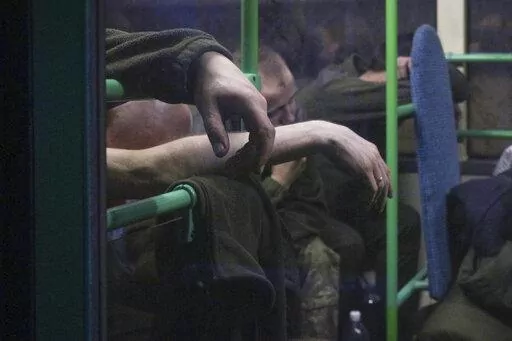 Ukrainian servicemen sit in a bus after they were evacuated from the besieged Mariupol's Azovstal steel plant, near a prison in Olyonivka, in territory under the government of the Donetsk People's Republic, eastern Ukraine, Tuesday, May 17, 2022. More than 260 fighters, some severely wounded, were pulled from a steel plant on Monday that is the last redoubt of Ukrainian fighters in the city and transported to two towns controlled by separatists, officials on both sides said. (AP Photo)