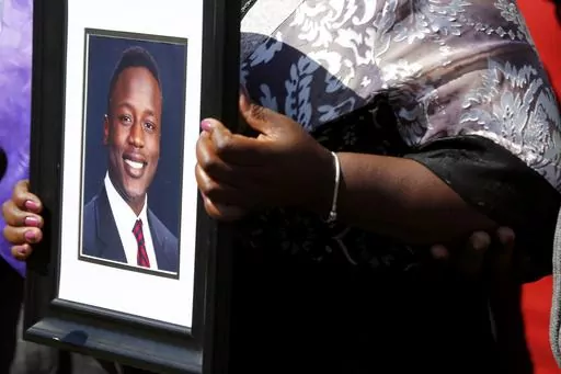 Caroline Ouko, mother of Irvo Otieno, holds a portrait of her son at the Dinwiddie Courthouse in Dinwiddie, Va., on Thursday, March 16, 2023. She said Otieno, who died in a state mental hospital March 6, was “brilliant and creative and bright.” (Daniel Sangjib Min/Richmond Times-Dispatch via AP)