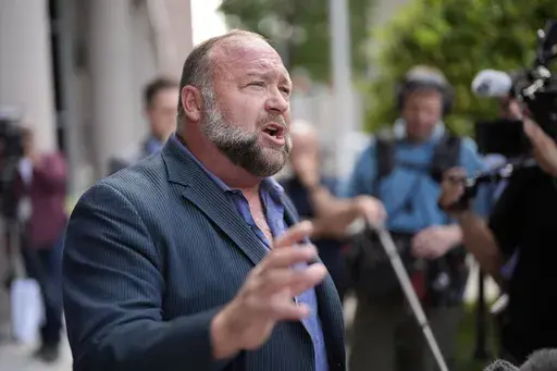Right-wing conspiracy theorist Alex Jones speaks to the media after arriving at the federal courthouse for a hearing in front of a bankruptcy judge, Friday, June 14, 2024, in Houston. (AP Photo/David J. Phillip, File)