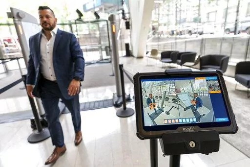Dominck D'Orazio, account executive for Evolv Technology, demonstrates the Evolv Express weapons detection system, which is showing red lights to flag a weapon he is wearing on his hip, Wednesday, May 25, 2022, in New York. (AP Photo/Mary Altaffer)