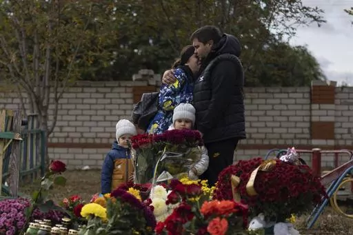 People react near the memorial for the victims of a Russian rocket attack in the village of Hroza near Kharkiv, Ukraine, Sunday, Oct. 8, 2023. A report by U.N investigators has pointed a finger at Russia as likely being responsible for the deaths of 59 civilians at a village café hit by a missile in eastern Ukraine in early October, in what was one of the deadliest strikes since the Kremlin’s forces launched a full-scale invasion 20 months ago. (AP Photo/Alex Babenko, File)