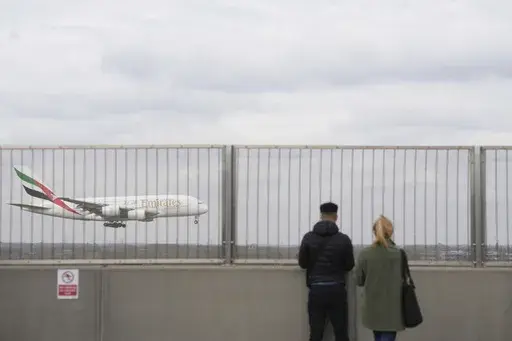People watch an Emirates plane at Heathrow Airport in London on Saturday March 22, 2025, after flights resumed at the west London airport on Friday evening. (Maja Smiejkowska/PA via AP)