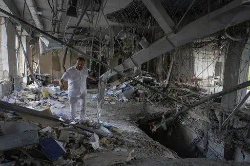 Alya Gali, a Gaza Strip-born doctor, looks at debris two weeks after a missile killed nine as it hit a private clinic where he has worked for most of his professional life in Kyiv, Ukraine, Monday, July 22, 2024. Russia’s full-scale invasion of Ukraine in 2022 catapulted Gali’s life into the chaos of constant air raids and missile attacks. Israel’s war on Hamas turned his hometown into a hellscape, uprooting his family and killing two of his relatives. (AP Photo/Efrem Lukatsky)