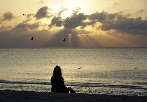 A woman meditates on the beach in Miami Beach, Fla., on Wednesday, April 28, 2010. According to a study published Wednesday, Nov. 9, 2022 in the journal JAMA Psychiatry, mindfulness meditation worked as well as a standard drug for treating anxiety in the first head-to-head comparison. (AP Photo/Lynne Sladky, File)