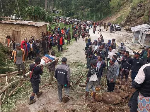 In this photo provided by the International Organization for Migration, an injured person is carried on a stretcher to seek medical assistance after a landslide in Yambali village, Papua New Guinea, Friday, May 24, 2024. More than 100 people are believed to have been killed in the landslide that buried a village and an emergency response is underway, officials in the South Pacific island nation said. The landslide struck Enga province, about 600 kilometers (370 miles) northwest of the capital, P