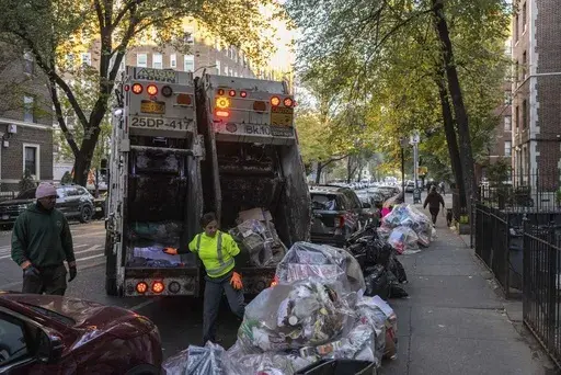 Sanitation workers collect trash, Saturday, Nov. 16, 2024, in the Brooklyn borough of New York. (AP Photo/Yuki Iwamura)