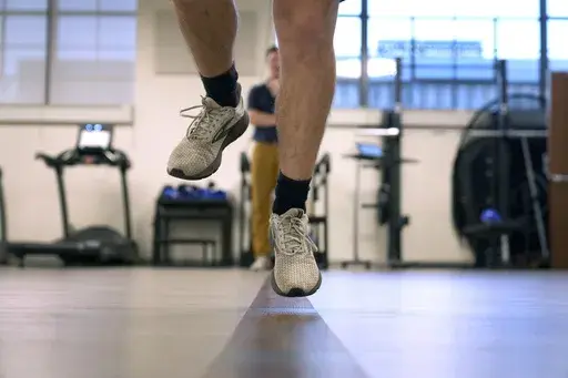 Jacob Bullard leaps in the air as part of a physical therapy exercise at WashU, Dec. 16, 2024, in St. Louis. (AP Photo/Jeff Roberson, File)