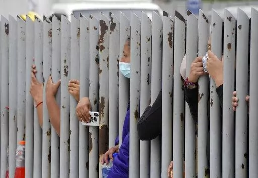 Relatives wait outside the morgue for news on their relatives who were inmates at the Litoral penitentiary, after deadly riots broke out inside the prison in Guayaquil, Ecuador, Sunday, Nov. 14, 2021. (AP Photo/Dolores Ochoa)