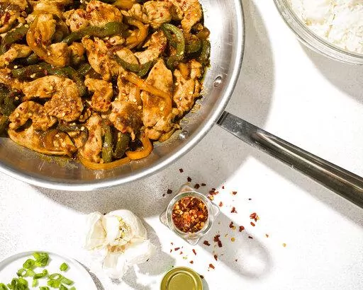 This image released by Milk Street shows a recipe for Stir-fried Hoisin Chicken and Bell Peppers. (Milk Street via AP)