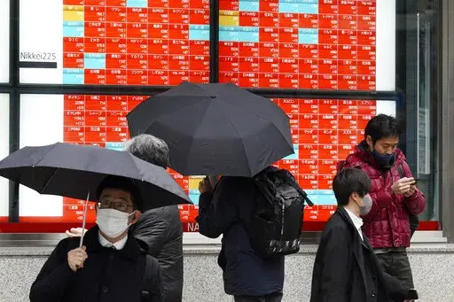 A person watches an electronic stock board showing Japan's Nikkei 225 index at a securities firm on Jan. 24, 2023, in Tokyo. Asian stock markets were mixed Thursday, Jan. 26, 2023 amid hopes Western economies can avoid a recession despite higher interest rates to cool inflation. (AP Photo/Eugene Hoshiko, File)