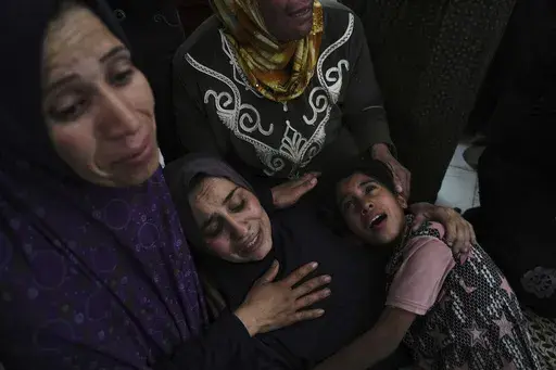 Palestinians grieve over the bodies of their relatives, who were killed in an Israeli airstrike, as they prepare for burial at a hospital in Beit Lahiya, Gaza Strip, on Wednesday, April 2, 2025. (AP Photo/Jehad Alshrafi)