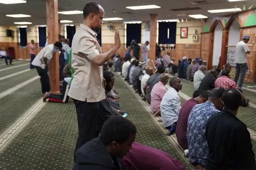Yusuf Abdulle, standing, director of the Islamic Association of North America, prays with fellow Muslims at the Abubakar As-Saddique Islamic Center in Minneapolis on Thursday, May 12, 2022. Minneapolis will allow broadcasts of the Muslim call to prayer at all hours, Thursday, April 14, 2023, becoming the first major U.S. city to allow the announcement or “adhan” to be heard over speakers five times a day, year-round. (AP Photo/Jessie Wardarski)