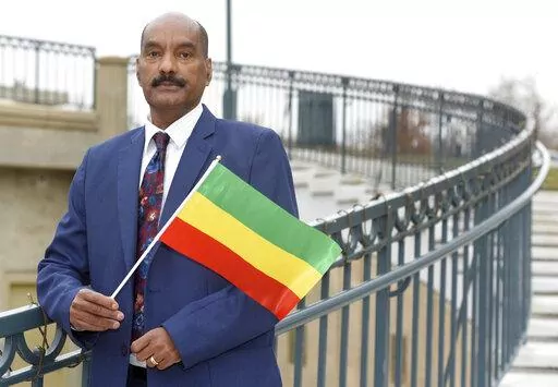 Negasi Beyene, who grew up in Mekele, the capital city of the Ethiopia's Tigray Region, holds a traditional Ethiopian flag Saturday, Dec. 18, 2021 in Columbia, Md. Beyene, who works as a biostatistician near Washington, identifies as a human rights activist for Ethiopian unity. “My motto is, ‘humanity before ethnicity.’” (AP Photo/Steve Ruark)