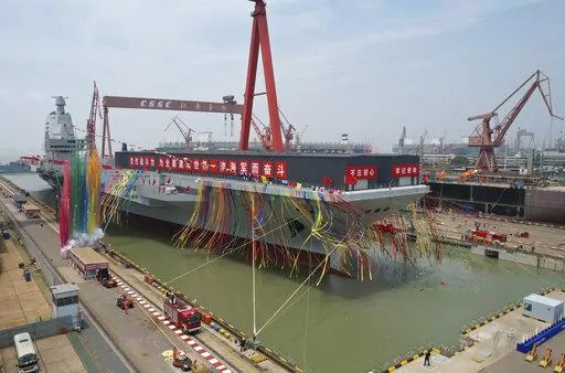 In this photo released by Xinhua News Agency, coloured smoke mark the launch ceremony for China's third aircraft carrier christened Fujian at a dry dock in Shanghai on Friday, June 17, 2022. China on Friday launched its third aircraft carrier, the first such ship to be both designed and built entirely within the country. (Li Gang/Xinhua via AP)